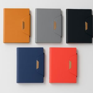 A line-up of seven professional notebooks in colors including green, gray, blue, brown, red, and black, featuring a faux leather cover, contrast stitching, and a silver metal clasp closure